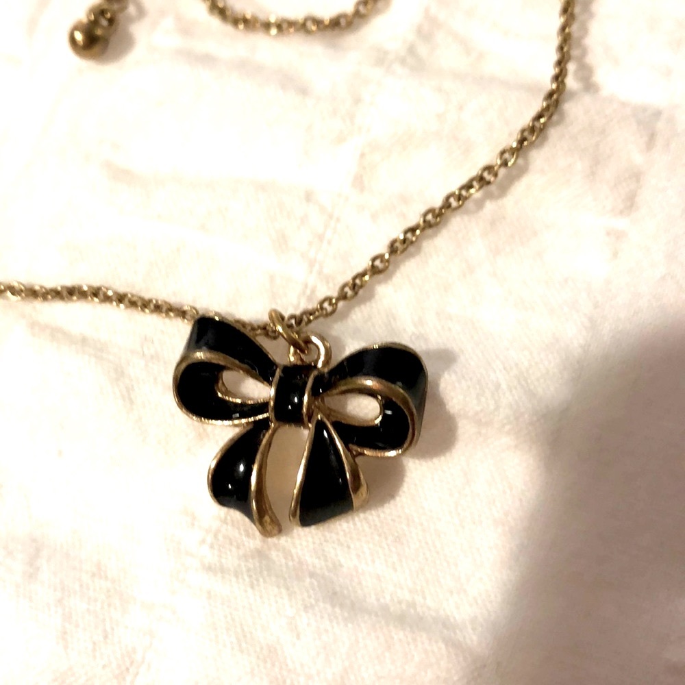 Gold tone and black enamel bow necklace
